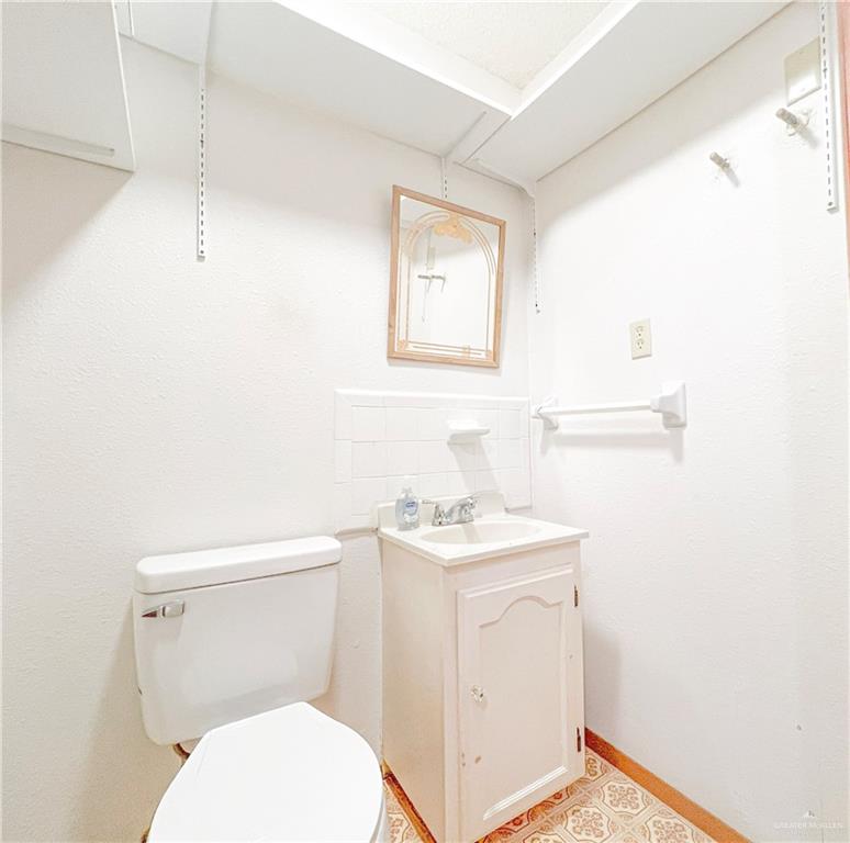 218 East Colorado Street Rio Hondo, TX 78583 - Photo 13 of 18 a white toilet sitting next to a bathroom sink