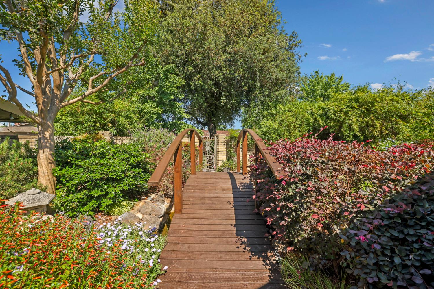 2406 Kenmore Court Modesto, CA 95350 - Photo 6 of 54 a view of a pathway with flower plants and wooden fence