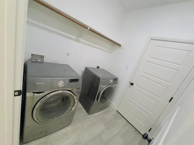 an empty room with wooden floor cabinet and windows