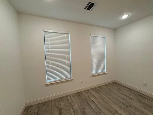 a view of an empty room and wooden floor