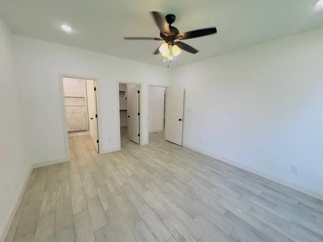 a room with walk in closet and wooden floor
