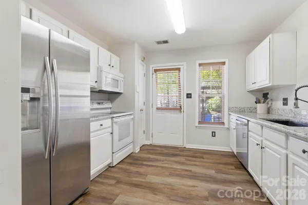 a kitchen with white cabinets and refrigerator