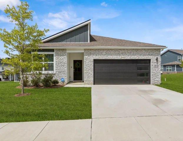 a front view of a house with a garden and yard