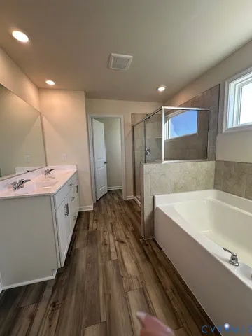a spacious bathroom with a tub double vanity sink and a mirror