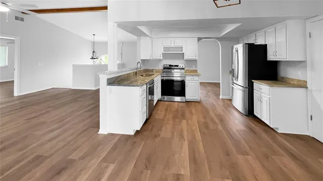 a kitchen with stainless steel appliances a stove top oven a sink dishwasher and a refrigerator