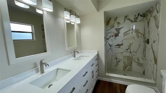 a bathroom with a sink a toilet and shower