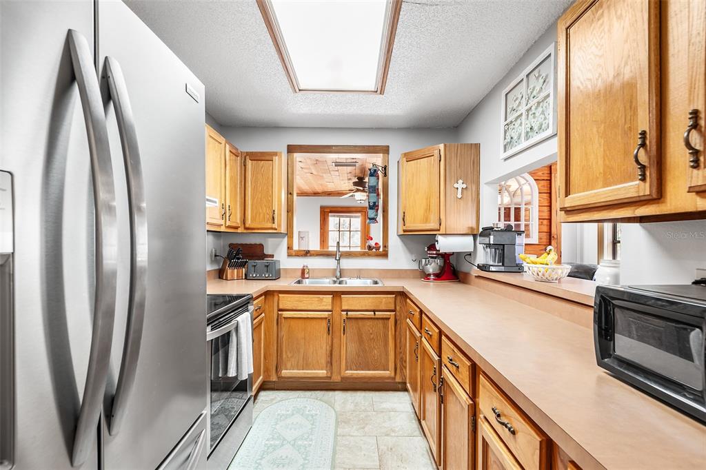 1233 St Anne Shrine Road Lake Wales, FL 33898 - Photo 8 of 47 a kitchen with stainless steel appliances granite countertop a sink a stove a refrigerator a washer dryer and a window
