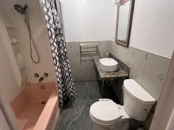 a bathroom with a sink a toilet a mirror and shower