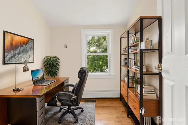 a view of a workspace with furniture and a window
