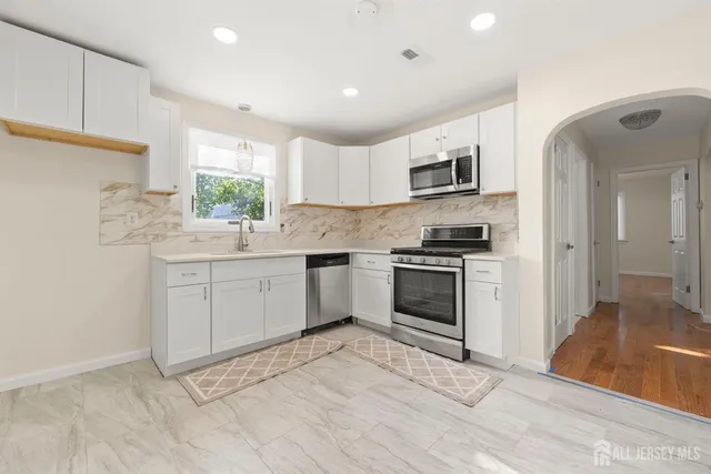 a kitchen with stainless steel appliances granite countertop a stove a sink and a refrigerator
