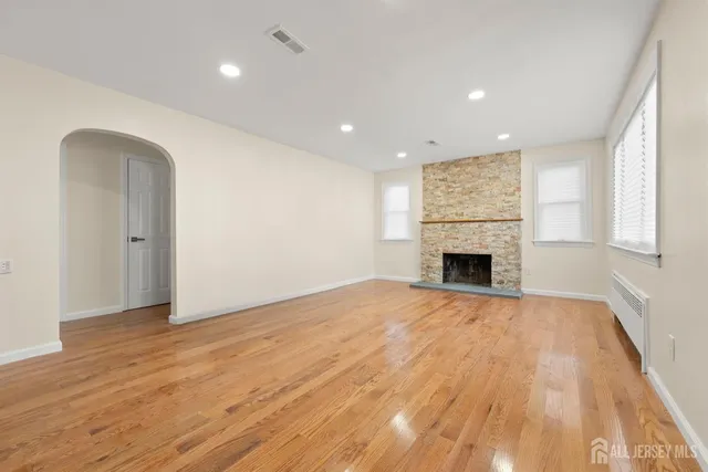 a view of empty room with wooden floor and fireplace