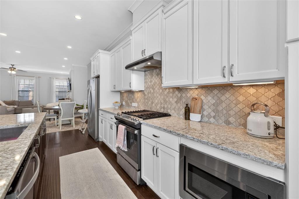 7012 Seneca Court Roswell, GA 30076 - Photo 13 of 65 a kitchen with granite countertop a sink a stove and cabinets