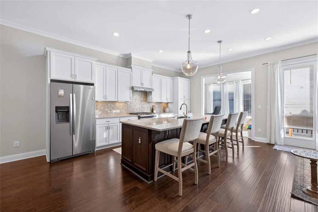 7012 Seneca Court Roswell, GA 30076 - Photo 41 of 65 a kitchen with stainless steel appliances granite countertop a dining table chairs refrigerator sink and cabinets