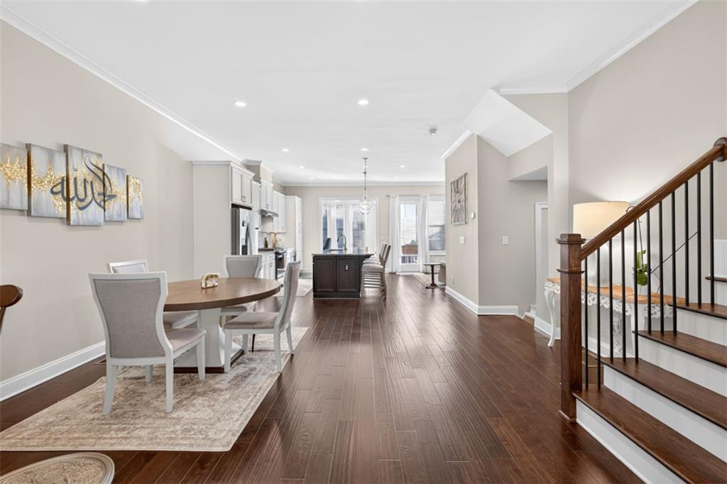 7012 Seneca Court Roswell, GA 30076 - Photo 43 of 65 a dining room with furniture wooden floor a rug and a painting