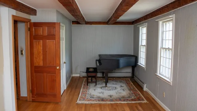 a view of a hallway with wooden floor and a window