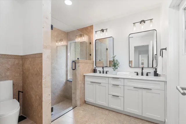a bathroom with a double vanity sink mirror and toilet