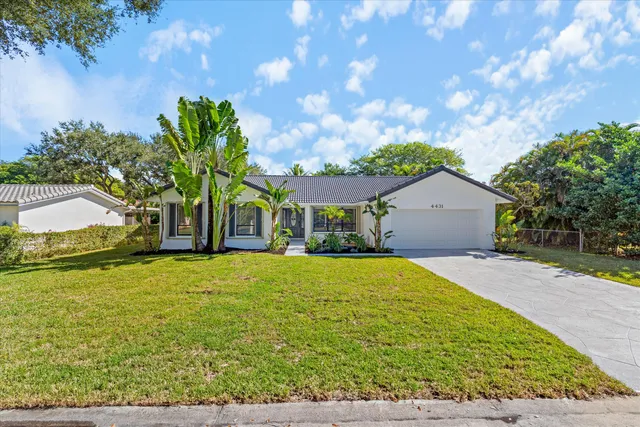 a front view of house with yard and trees in the background