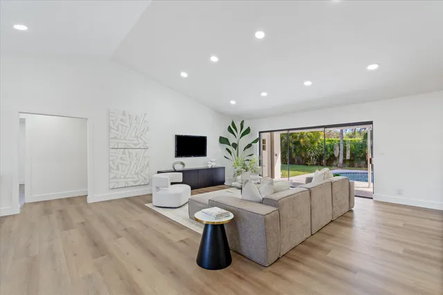 a living room with furniture flat screen tv and a large window
