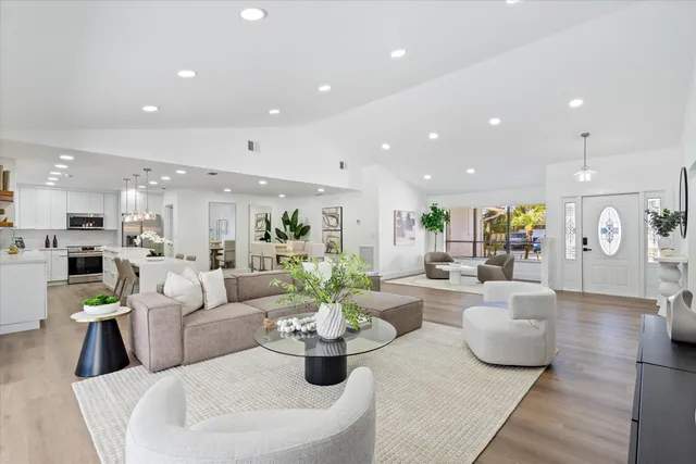 a living room with fireplace furniture and a view of kitchen
