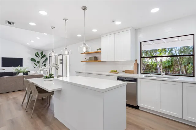 a kitchen with a table chairs refrigerator and microwave