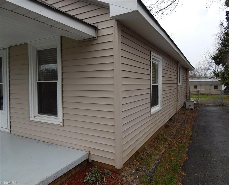 7830 Cherry Street Rural Hall, NC 27045 - Photo 18 of 21 Paved parking along the side of the home, also shows gate to fenced back yard!