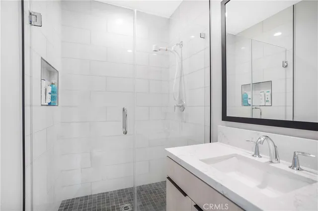 a bathroom with a sink shower and a mirror