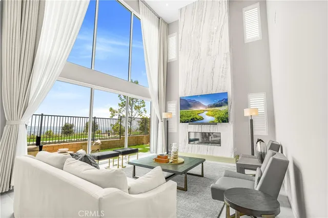 a living room with furniture a large window and a flat screen tv