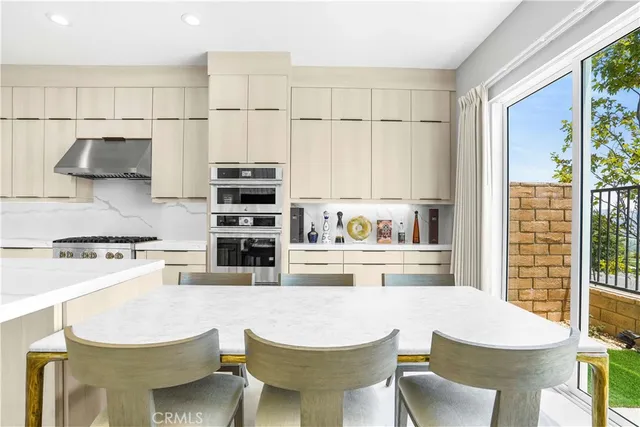 a kitchen with stainless steel appliances a stove a table and chairs in it
