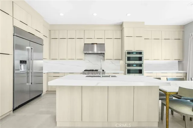 a kitchen with stainless steel appliances granite countertop a stove a sink and a refrigerator