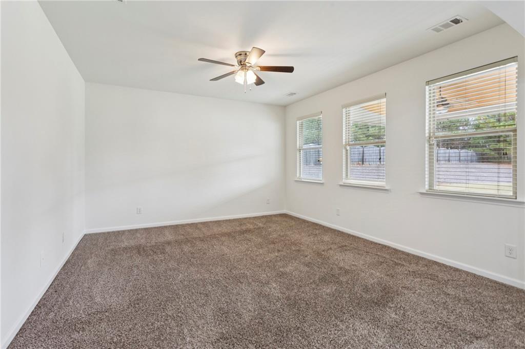 312 Upper Pheasant Court Ball Ground, GA 30107 - Photo 6 of 19 an empty room with windows and chandelier fan