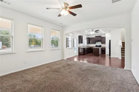 a view of a livingroom with furniture a kitchen stove and a window