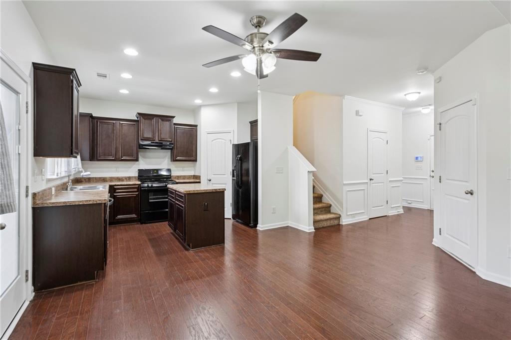 312 Upper Pheasant Court Ball Ground, GA 30107 - Photo 8 of 19 a kitchen with a refrigerator a stove top oven a sink dishwasher and a dining table with wooden floor