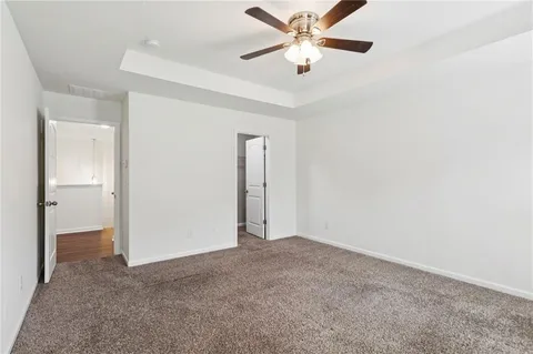 an empty room with closet and a chandelier fan