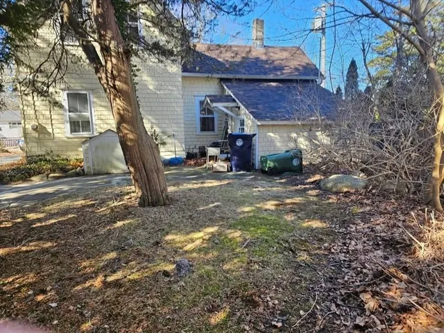 a view of a house with backyard and a tree