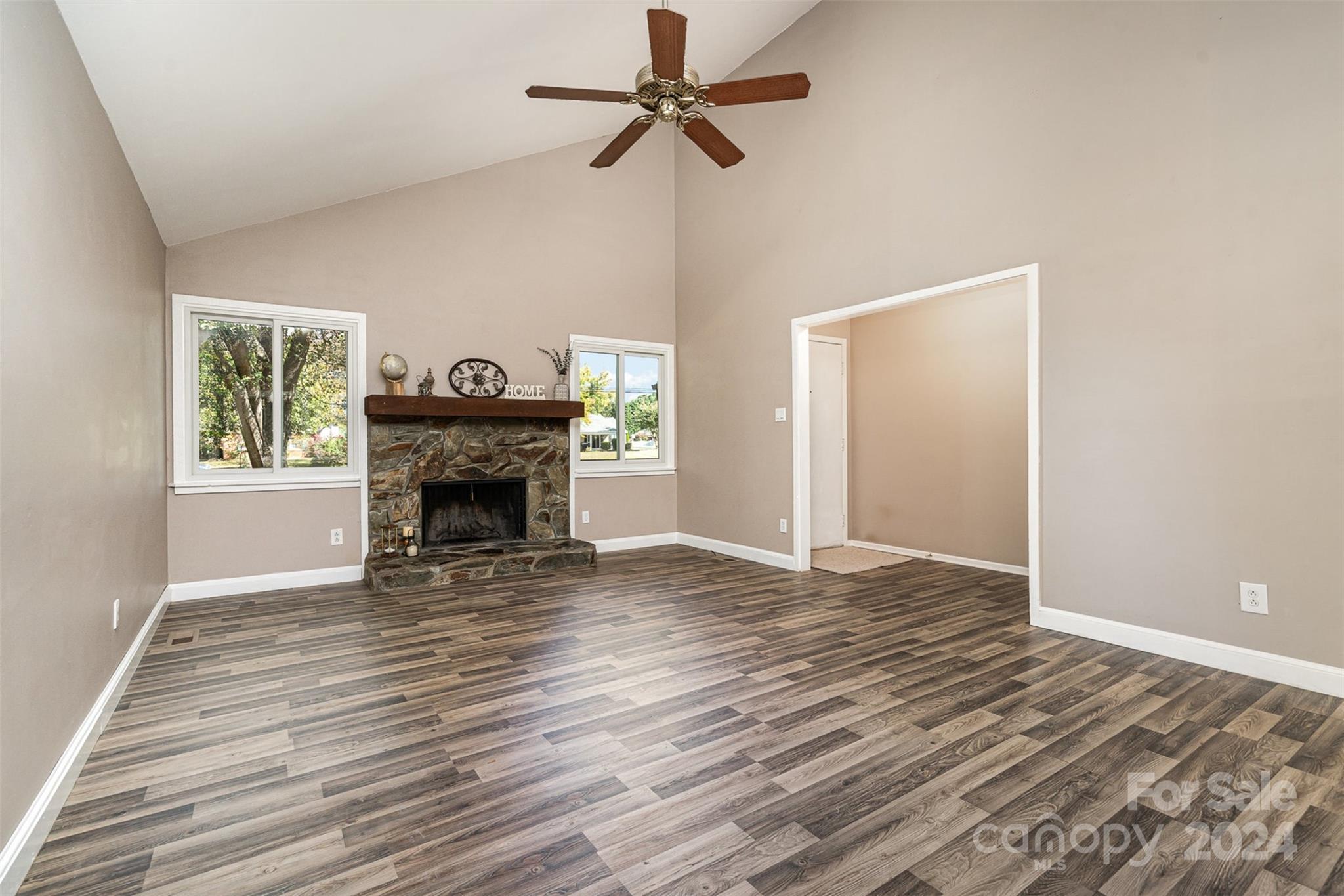 1316 Reid Harkey Road Matthews, NC 28105 - Photo 8 of 35 a view of a livingroom with a fireplace a ceiling fan and wooden floor