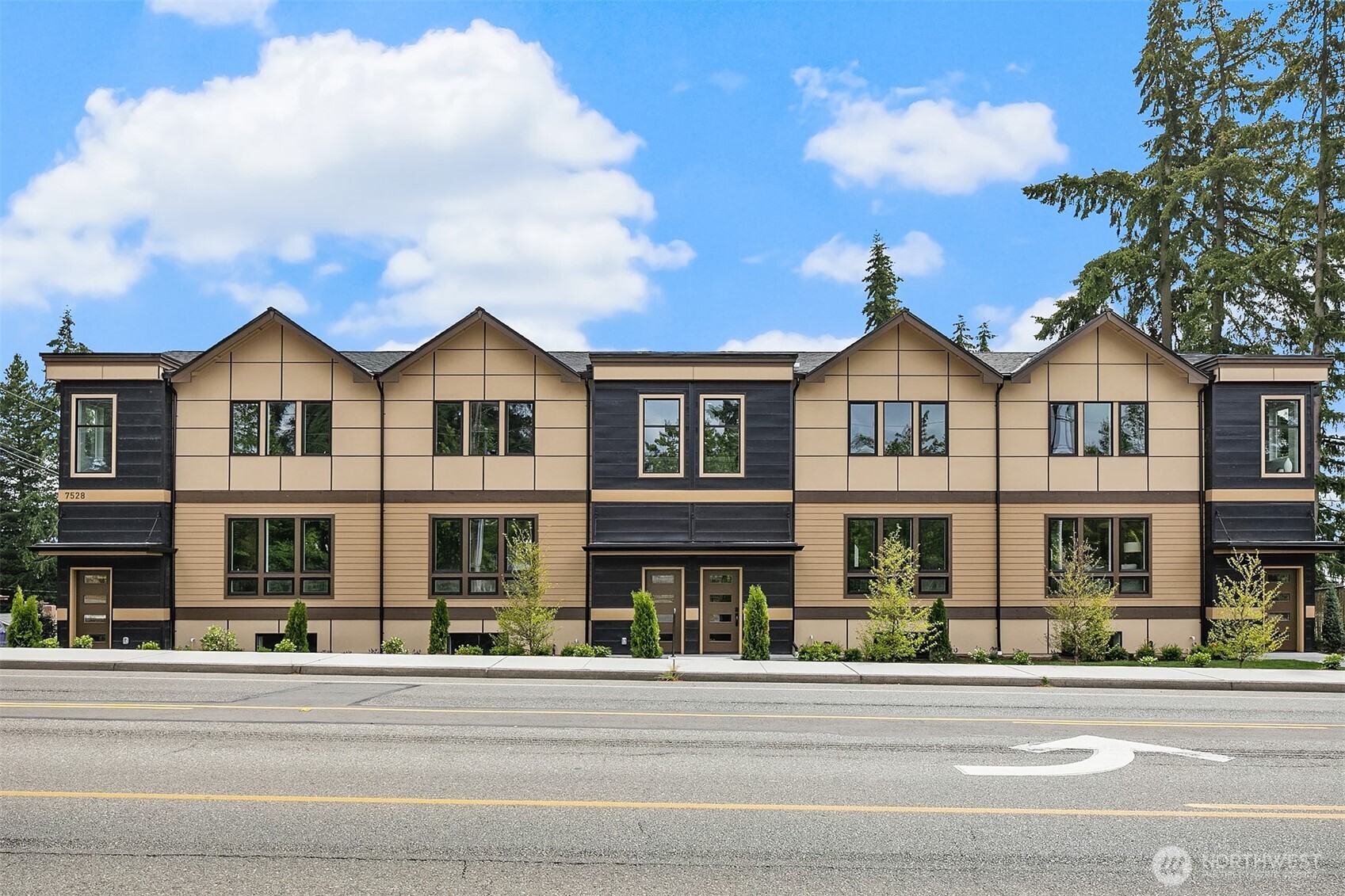 7528 215th Street Southwest, Unit 101 Edmonds, WA 98026 - Photo 28 of 29 a view of a brick house with a fountain plants and large trees