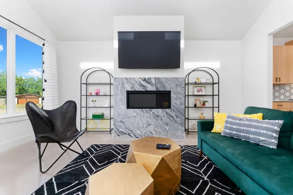 a living room with furniture a flat screen tv and a fireplace