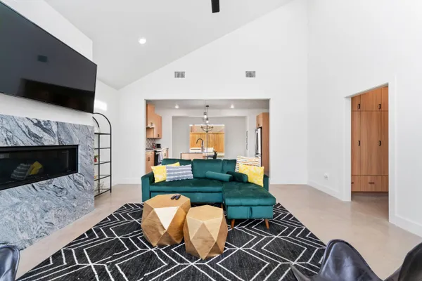 a living room with furniture a flat screen tv and kitchen view