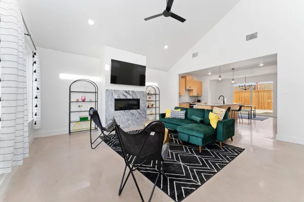 a living room with furniture a flat screen tv and a fireplace