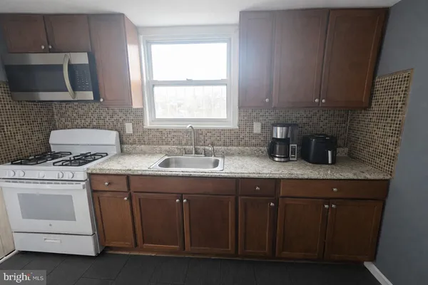 a kitchen with sink a microwave and cabinets