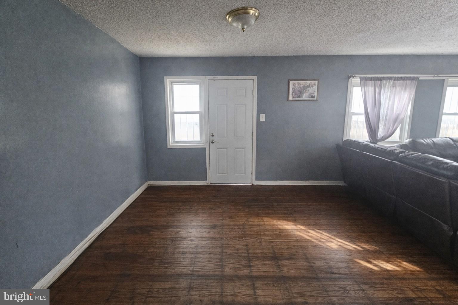1438 Perkins Street Chester, PA 19013 - Photo 4 of 10 an empty room with wooden floor and windows