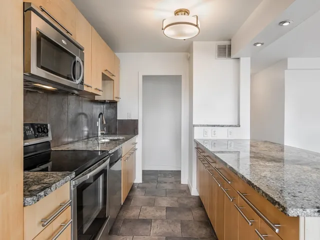 a kitchen with stainless steel appliances granite countertop a sink stove oven and refrigerator