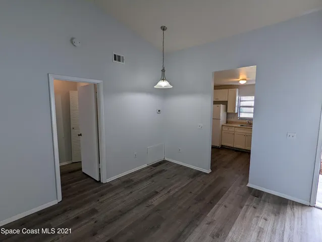 a view of a room with wooden floor and a ceiling fan