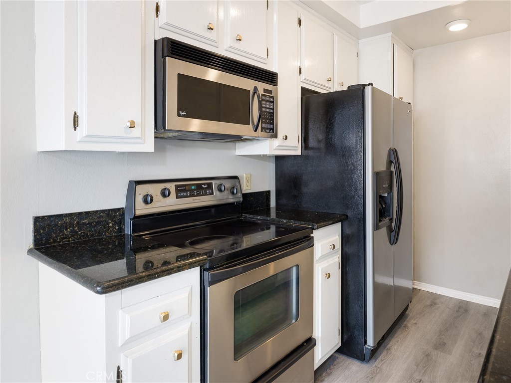 2015 Bataan Road, Unit 105 Redondo Beach, CA 90278 - Photo 12 of 29 a kitchen with stainless steel appliances granite countertop a stove microwave and refrigerator