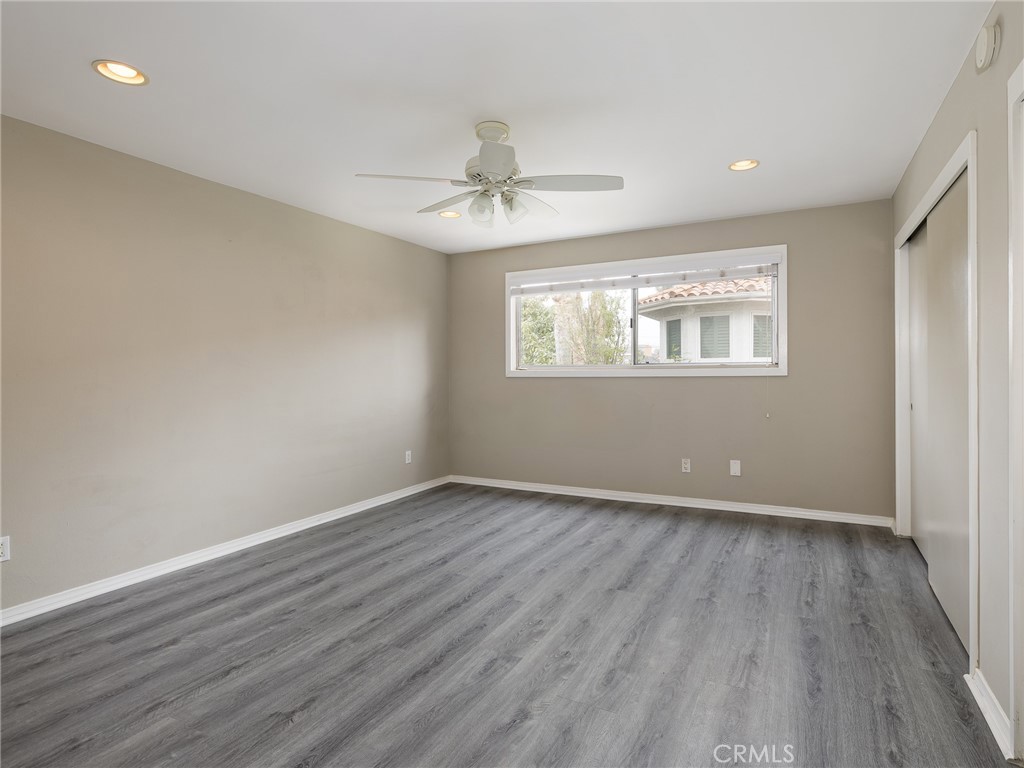 2015 Bataan Road, Unit 105 Redondo Beach, CA 90278 - Photo 15 of 29 an empty room with wooden floor ceiling fan and windows
