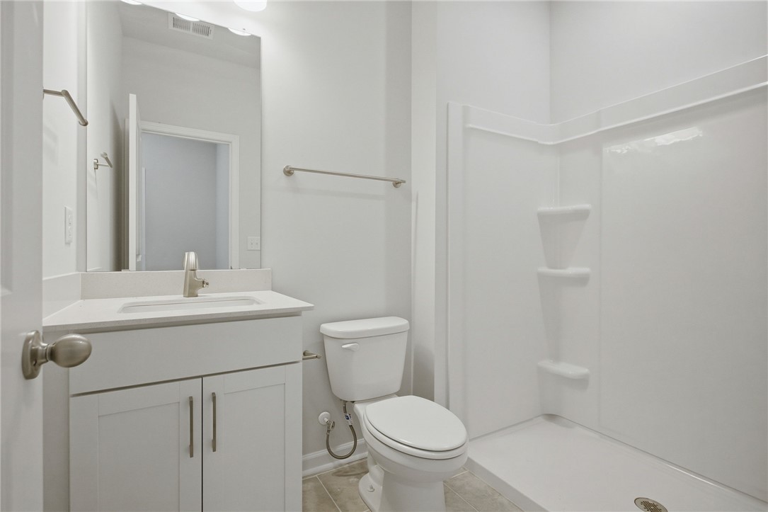 557 Hydrangea Street, Unit LOT 46 Seneca, SC 29678 - Photo 15 of 37 A well-lit, contemporary bathroom offers a practical walk-in shower and a sleek vanity with ample storage.