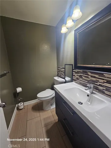 a bathroom with a sink a toilet and a mirror