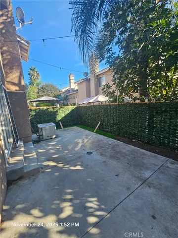 a view of a patio with table and chairs with wooden fence