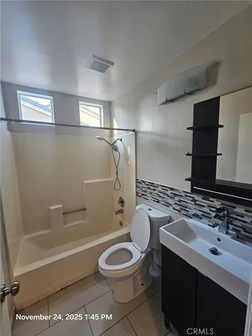 a bathroom with a granite countertop toilet sink and mirror