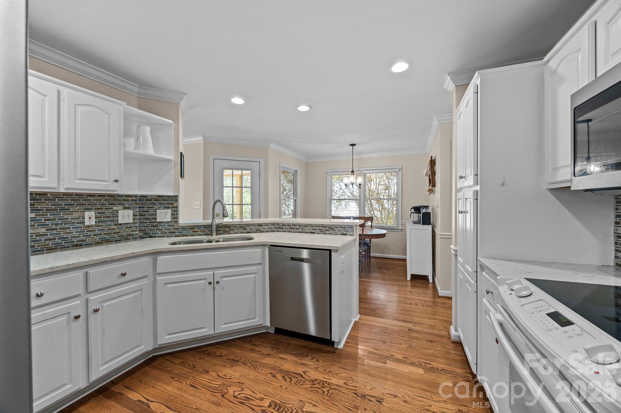 413 Nixon Road Belmont, NC 28012 - Photo 13 of 48 a large kitchen with stainless steel appliances granite countertop a lot of counter space and wooden floors